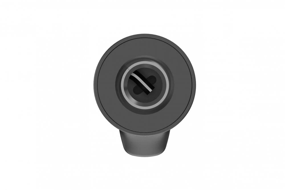 Black circular object with a central hole on a white background