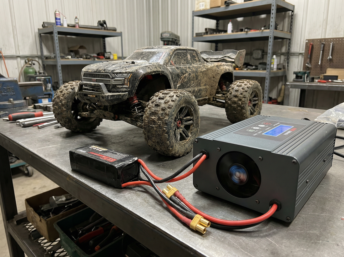 A modern, multi-channel smart RC battery charger on a clean workshop bench.