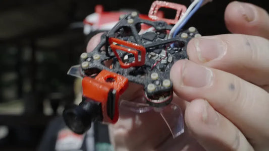 Two tiny 3D-printed FPV drones with spare parts and packaging.