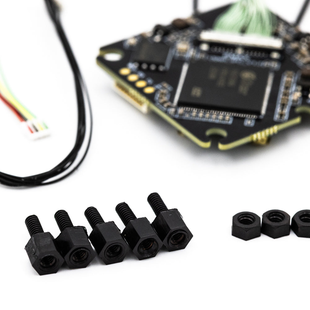 Black screws and nuts with a blurred electronic component in the background