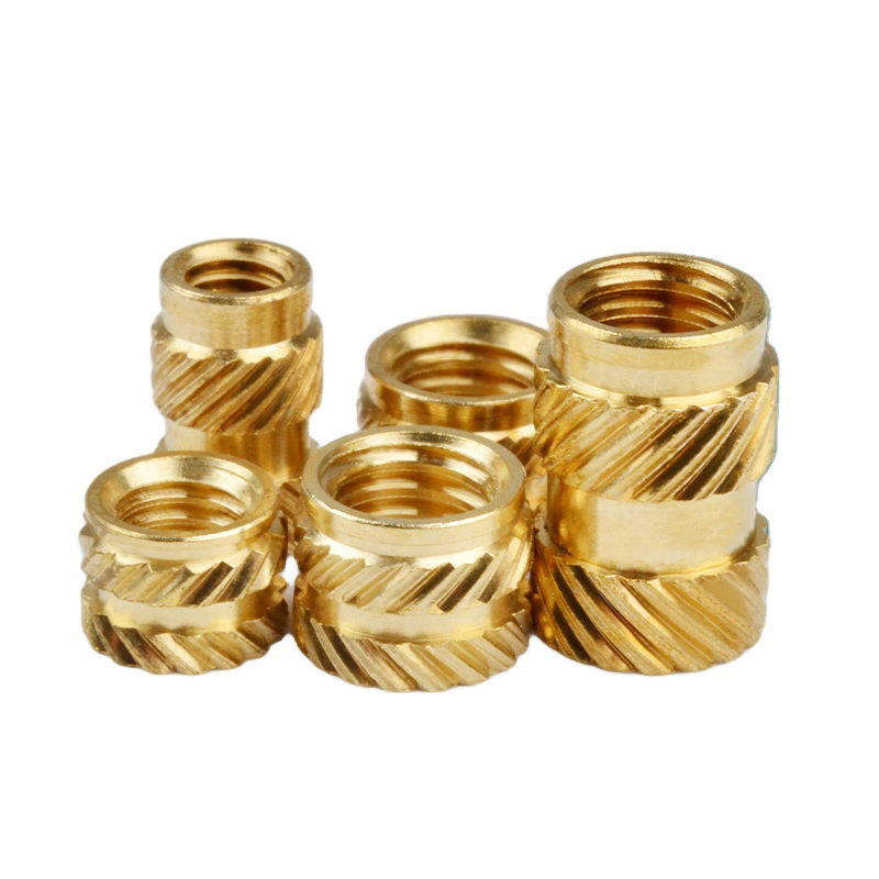 Set of gold metal thread inserts on a white background