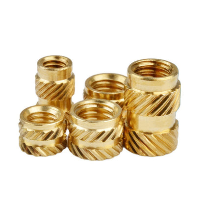 Set of gold metal thread inserts on a white background